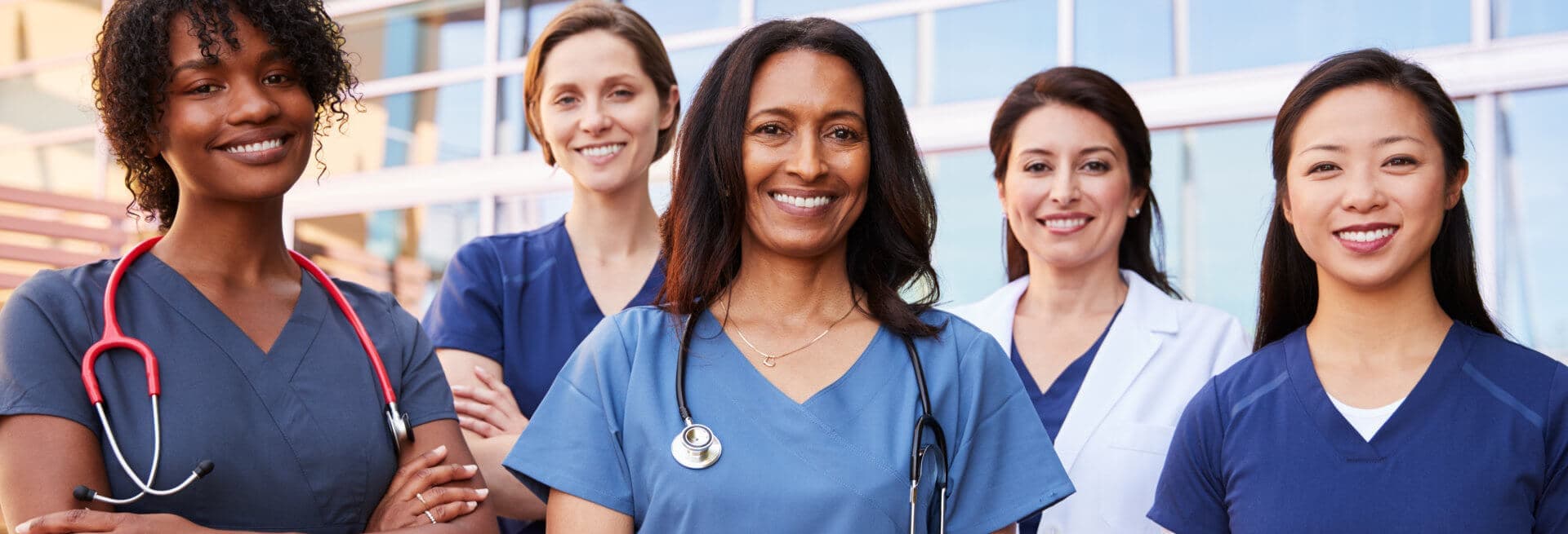 multiracial female doctors smiling at camera