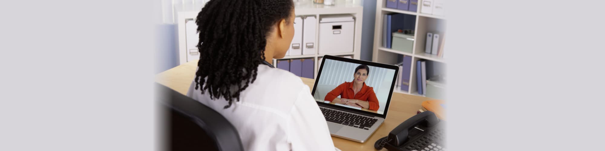 Female patient talking to African American doctor over video chat